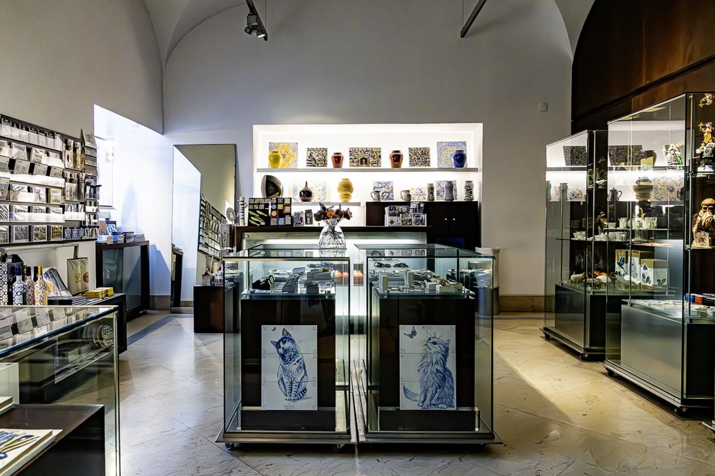Interior da loja, com vitrinas, edições e reproduções de azulejo